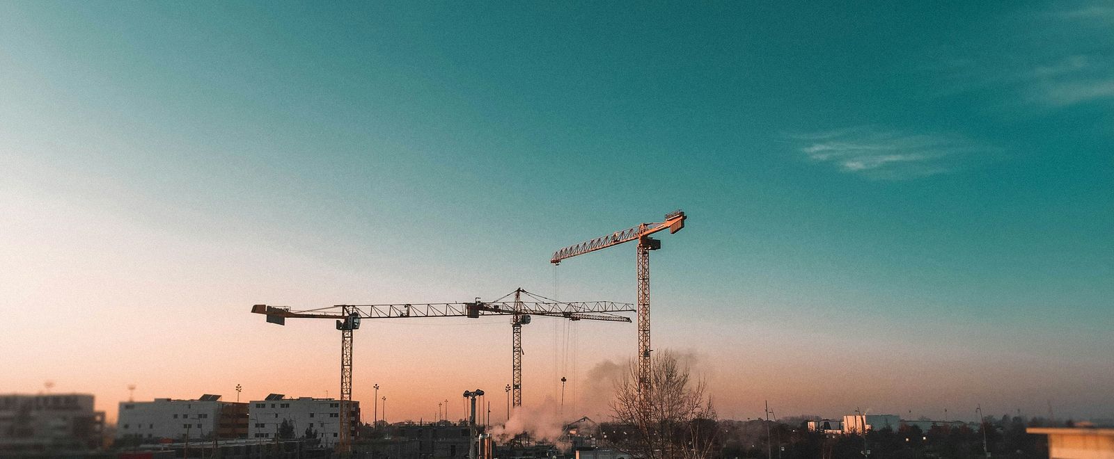 Tower cranes over a development at dusk